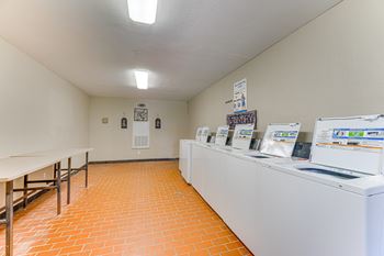 A laundromat with a row of washers and dryers.